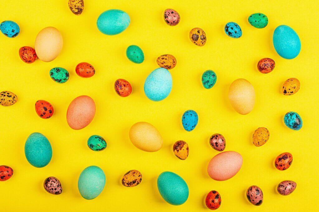 Flat Lay of Colored Easter Eggs on Yellow Background
