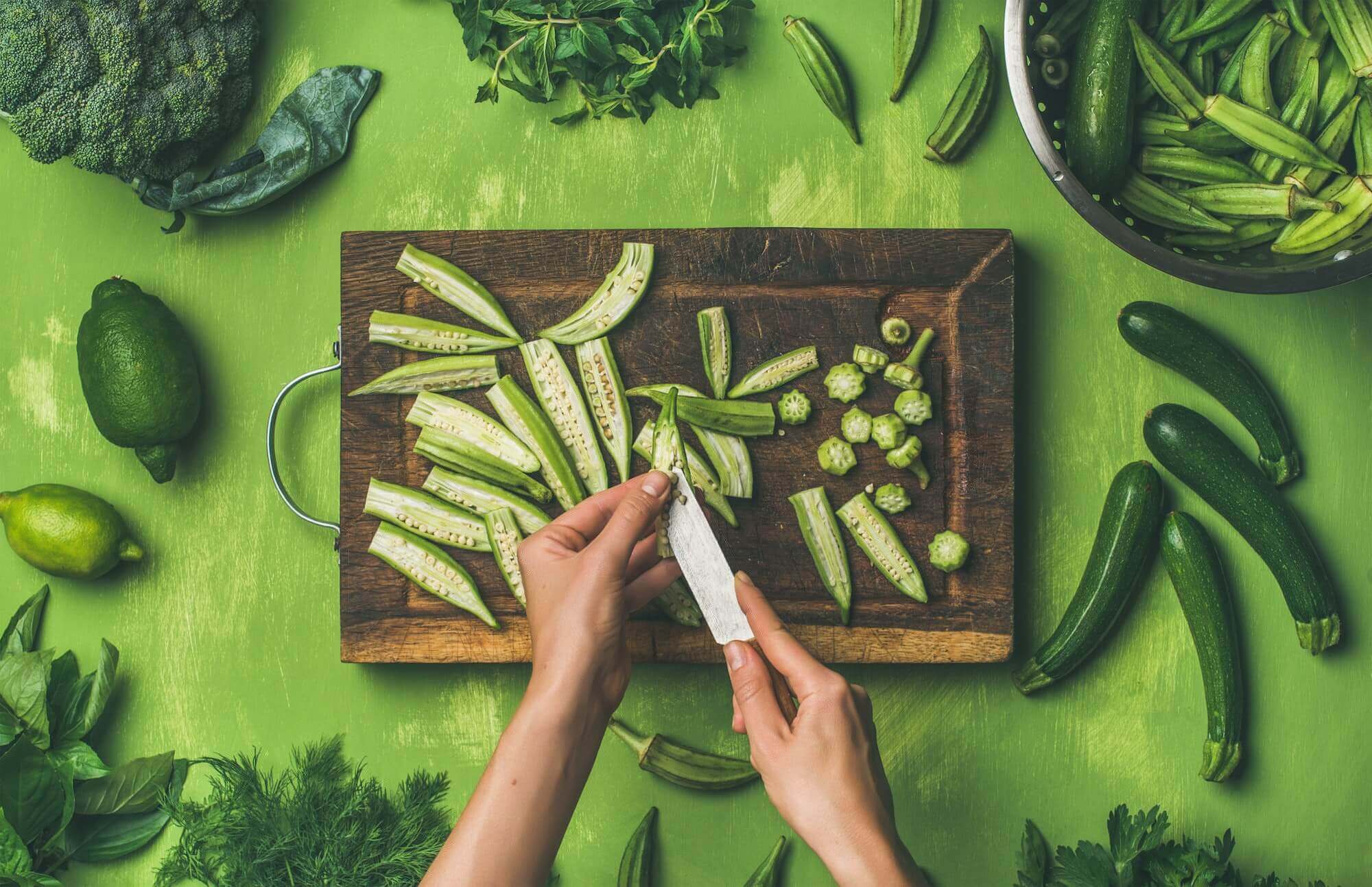 Woman hands cutting green vegetables and greens, top view Woman hands cutting green vegetables and greens, top view